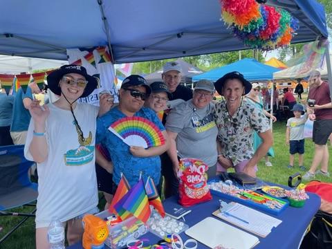 Group of 正规赌博十大网站 instructors and students wearing rainbows at the Rochester PRIDE event.